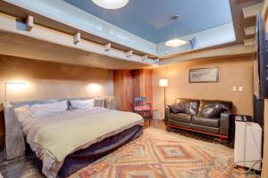 a bedroom with a bed and a leather couch at Studio 2 Blocks From Downtown Santa Fe Plaza! in Santa Fe