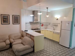 a kitchen with a counter and two chairs and a refrigerator at Beach casa sul mare in Termoli