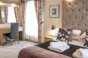 a hotel room with a bed and a desk and a desk at Stewarts Resort Lodge 16 in St. Andrews