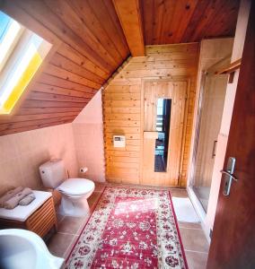 a bathroom with a toilet and a rug at chata ,,Na Brehu'' in Klokočov