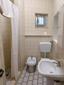 a white bathroom with a toilet and a sink at Beach casa sul mare in Termoli +28 photos