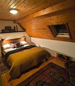 sypialnia z łóżkiem w pokoju z drewnianymi ścianami w obiekcie chata ,,Na Brehu'' w mieście Klokočov