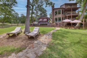 dos bancos sentados frente a una casa en Beautiful Lakehouse with Hot Tub, Boathouse and Kayaks, en Blanchard