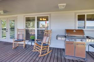 a patio with a grill and two chairs on a porch at Spacious Livingston Home with Private Boat Dock in Livingston