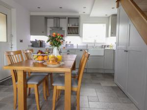 a kitchen with a wooden table with a bowl of fruit at Gwynfa in Bala