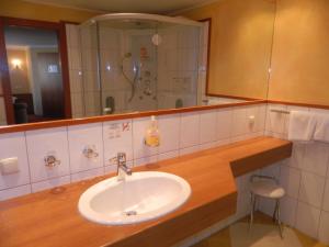 a bathroom with a sink and a shower at Gasthaus - Pension Kärntnerhof in Faak am See