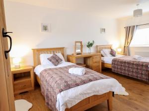 a bedroom with two beds and two tables and a window at Gwynfa in Bala