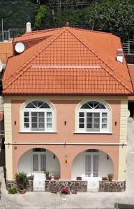 une petite maison avec un toit orange dans l'établissement Relais Capitolo, à Maiori