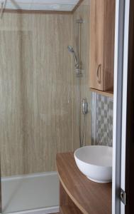 bagno con lavandino bianco e doccia di Stewarts Resort Lodge 26 a St Andrews