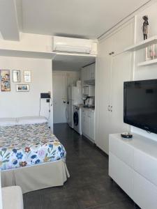 a bedroom with a bed and a flat screen tv at Céntrico apartamento en el Riscal in Alicante +9 photos