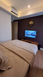 雅加達的住宿－gold coast studio Netflix wifi paris room sofabed，一间卧室配有一张大床和一台平面电视