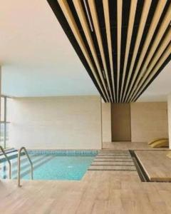 雅加達的住宿－gold coast studio Netflix wifi paris room sofabed，一座带大型天花板的建筑中的游泳池