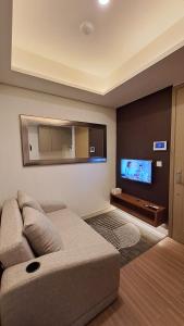 雅加達的住宿－gold coast studio Netflix wifi paris room sofabed，带沙发和平面电视的客厅