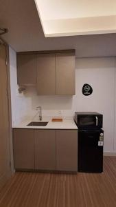 雅加達的住宿－gold coast studio Netflix wifi paris room sofabed，厨房配有水槽和黑冰箱。