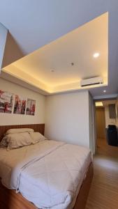 雅加達的住宿－gold coast studio Netflix wifi paris room sofabed，一间卧室设有一张带天花板的大床
