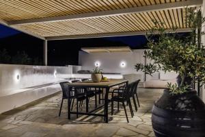 an outdoor patio with a wooden table and chairs at Casa Naturale in Skopelos Town