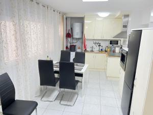 a kitchen with a table and chairs in a kitchen at Edificio Gloria in Los Cristianos