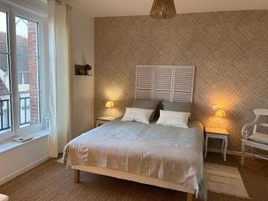 une chambre avec un lit avec deux lampes et une fenêtre dans l'établissement Appartement Cote des Isles, à Barneville-Carteret