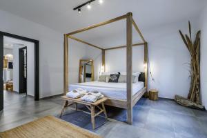 a bedroom with a canopy bed with towels on a bench at Casa Naturale in Skopelos Town