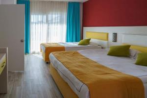 two beds in a hotel room with red walls at Side Win Hotel & Spa - All Inclusive in Side