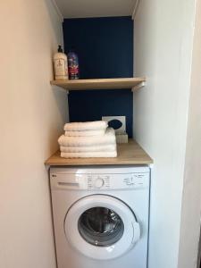 - une buanderie avec un lave-linge et un sèche-linge sur une étagère dans l'établissement Appartement Cote des Isles, à Barneville-Carteret