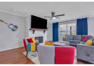 ein Wohnzimmer mit 2 Sofas und einem TV in der Unterkunft Lakeside Family Oasis in Savannah