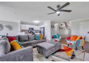 ein Wohnzimmer mit einem Sofa und Stühlen sowie einem Deckenventilator in der Unterkunft Lakeside Family Oasis in Savannah