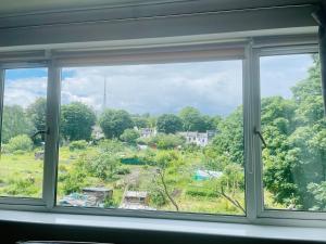 a window with a view of a field at Modern and chic rooms with beautiful landscape views in Sydenham