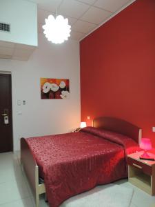 a bedroom with a bed with a red wall at Albergo Ma.Re in Popoli