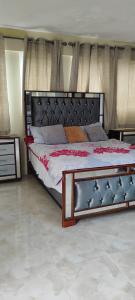 a bedroom with a large bed with a black headboard at Apartamento Mariam in La Puntica de Juan Dolio
