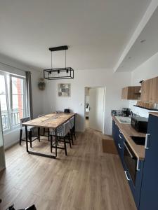 une cuisine et une salle à manger avec une table et des chaises dans l'établissement Appartement Cote des Isles, à Barneville-Carteret