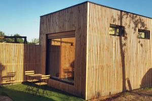 a small wooden building with a table and chairs at Chez Aurel et Nico. in La Lande-de-Fronsac