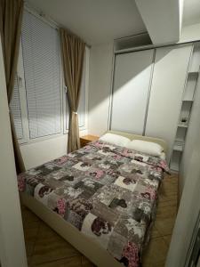 a bedroom with a bed with a quilt on it at Gold Apartment in Ohrid