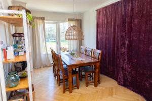 a dining room with a wooden table and chairs at Duveslätt B & B in Åskloster