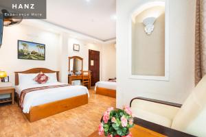 Cette chambre comprend deux lits et un bureau. dans l'établissement HANZ Queen Airport Hotel, à Hô-Chi-Minh-Ville