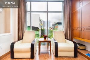 two chairs and a table in a room with a window at HANZ Queen Airport Hotel in Ho Chi Minh City