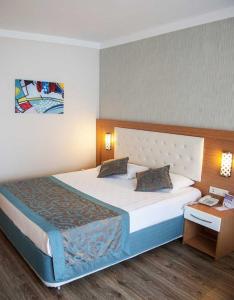 ein Hotelzimmer mit einem großen Bett und einem Tisch in der Unterkunft Side Win Hotel & Spa - All Inclusive in Side