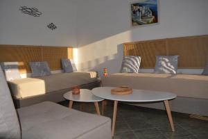 Habitación con sofá, cama y mesas. en Klados Studios & Apartments, en Cherronisos