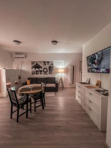 a kitchen and living room with a table and a couch at xOază Urbană în Inima Copoului - 2 camere - AB Homes - parcare in Iaşi