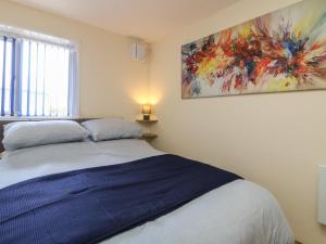 a bedroom with a bed with a painting on the wall at Flat 1 Marina Court in Redruth