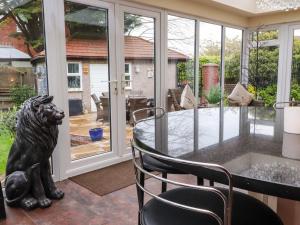 a dining room with a glass table with a lion statue at Linwood in Thornton