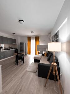 a living room with a black couch and a kitchen at xOază Urbană în Inima Copoului - 2 camere - AB Homes - parcare in Iaşi