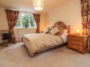 a bedroom with a bed and a dresser and a window at Linwood in Thornton