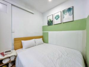 a bedroom with a bed and three pictures on the wall at The Song Boutique Vung Tau in Vung Tau