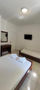 Pokój z dwoma łóżkami i telewizorem na ścianie w obiekcie KANALI HOLIDAYS APARTMENT 1 w Kanalionie