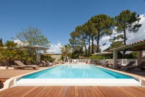 a swimming pool with chaise lounge chairs next to a resort at Résidence Marina Rossa in Porto-Vecchio