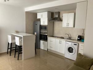 a kitchen with white cabinets and a washer at Disfruta Jerez in Jerez de la Frontera