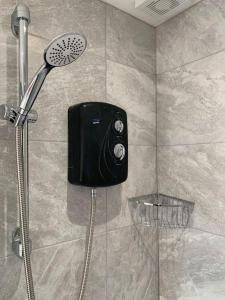 prysznic z czarnym telefonem w kabinie prysznicową w obiekcie Cosy Valley-View Cottage - Hot Tub, Free Parking, Countryside Views w mieście Barham