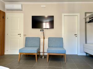 due sedie blu e una lampada in una stanza di Camere di Bianca a Foligno