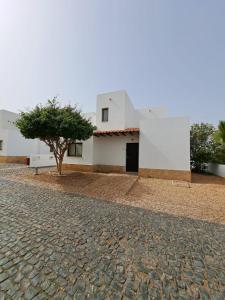 a building with a tree in front of it at Spacious family friendly 3-Bed Villa Dunas Resort in Santa Maria